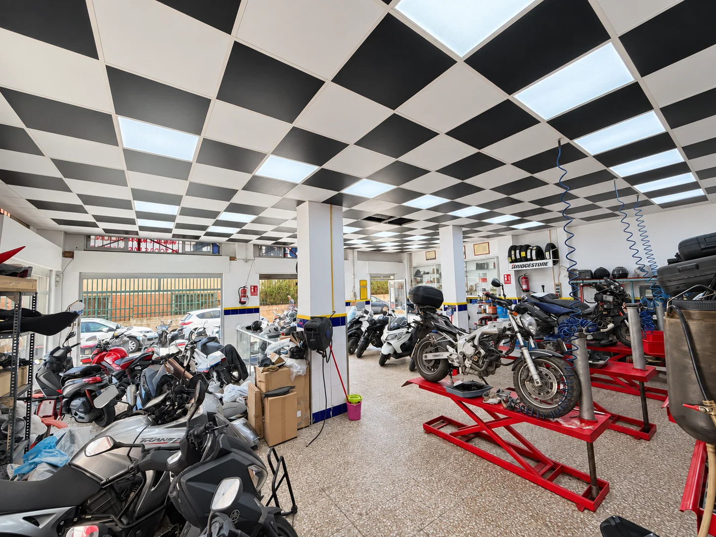 Vista amplia del interior de SotoMoto con motocicletas y elevadores