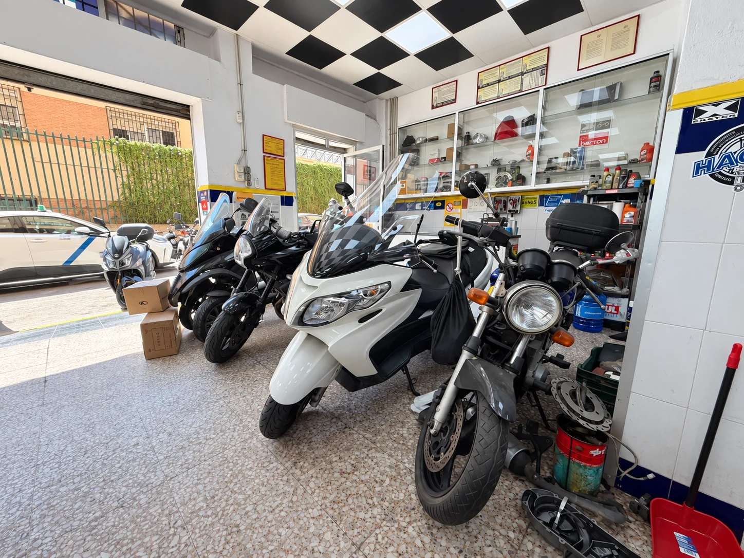 Scooters y motocicletas junto a la entrada del taller SotoMoto